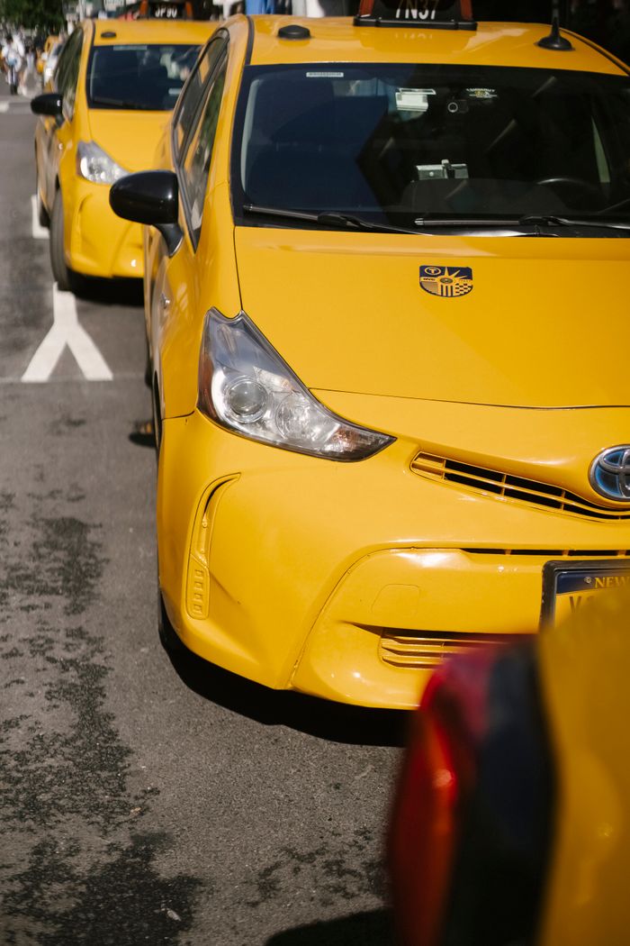 From above of bright yellow modern sports cab cars parked on urban roadway in sunlight